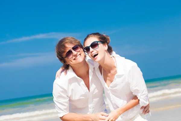 Porträt eines glücklichen jungen Paares mit Sonnenbrille in weißer Kleidung, das im Freien lächelt — Stockfoto