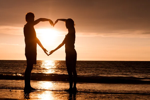 Silhouet van twee mensen in liefde bij zonsondergang — Stockfoto