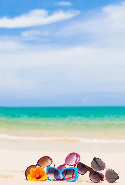 Many sunglasses lying on tropical lying beach — Stock Photo, Image