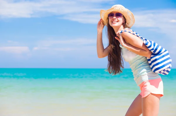 Vista trasera de una mujer con bolsa en la playa —  Fotos de Stock