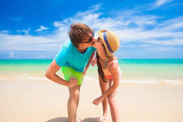 Giovane coppia felice in vestiti colorati baciare in spiaggia — Foto Stock