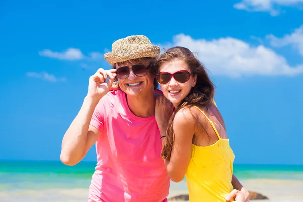 Joven en sombrero de paja con su novia en la playa tropical — Foto de Stock