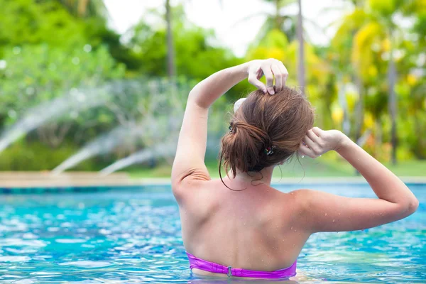 Jovem bela mulher relaxante na piscina spa — Fotografia de Stock