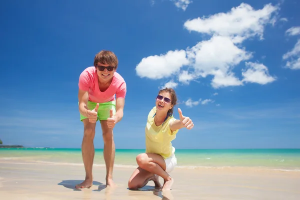 Mutlu genç çift parlak giysiler ve tropik sahilde eğleniyor güneş gözlüğü portresi — Stok fotoğraf