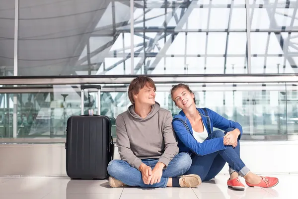 Jovem casal esperando no terminal do aeroporto — Fotografia de Stock