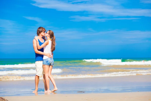 Feliz joven pareja besándose en tropical playa — Foto de Stock