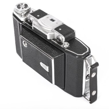 old camera with an accordion lens closed on a white background isolate