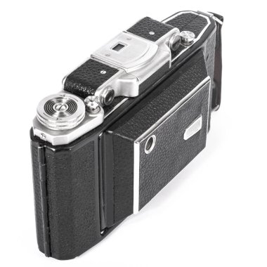 old camera with an accordion lens closed on a white background isolate