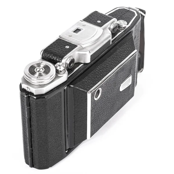 old camera with an accordion lens closed on a white background isolate