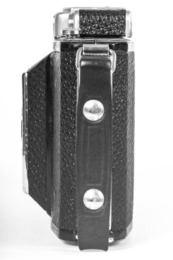 old camera with an accordion lens closed on a white background isolate
