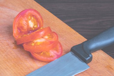 chopped tomatoes into pieces and a sharp knife on a cutting board