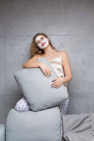 Ragazza Siede Sul Divano Indossando Una Maschera Cosmetica — Foto Stock