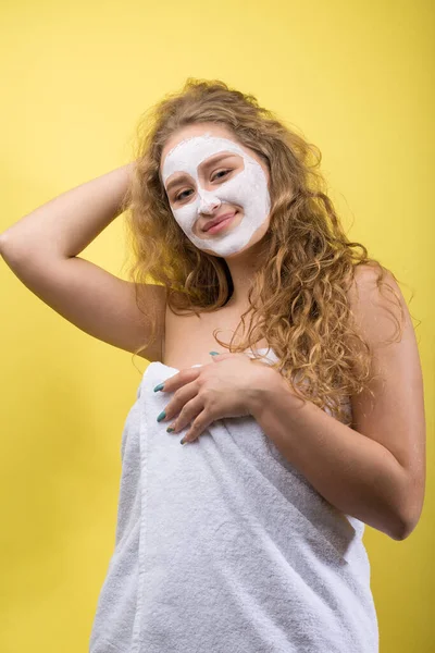 女の子とともに化粧品マスクで彼女の顔に白いタオル — ストック写真