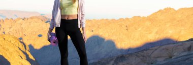 Spor giyimli genç, zayıf, atletik bir kız bir takım egzersizler yapıyor. Fitness ve sağlıklı yaşam tarzı.