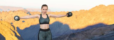 Spor giyimli genç, zayıf, atletik bir kız bir takım egzersizler yapıyor. Fitness ve sağlıklı yaşam tarzı.