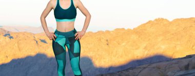 Spor giyimli genç, zayıf, atletik bir kız bir takım egzersizler yapıyor. Fitness ve sağlıklı yaşam tarzı.