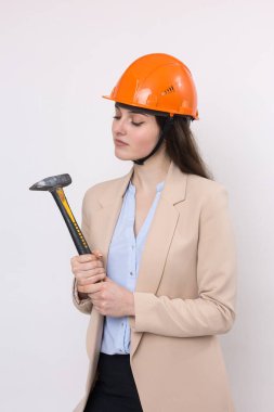Beyaz arka planda çekici olan turuncu miğferli bir kız mühendis..