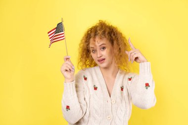 Yüzünde bir gülümseme olan genç mutlu bir kız ellerinde bir Amerikan bayrağı tutuyor. Vatanseverliğin ve özgürlüğün sembolü..