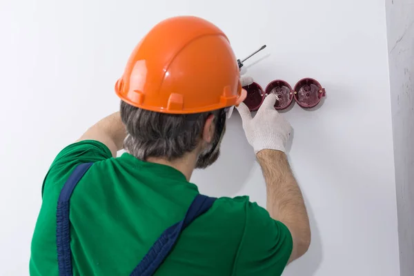 Elektriker Installerar Uttag Lägenheten Kille Orange Hjälm Och Overaller Gör — Stockfoto