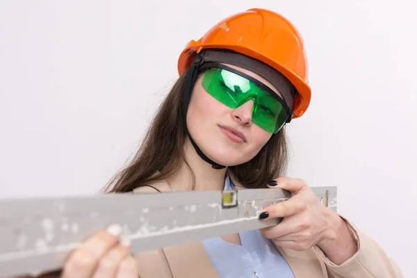 Menina Engenheira Capacete Construção Laranja Com Nível Edifício Suas Mãos — Fotografia de Stock