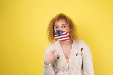 Yüzünde bir gülümseme olan genç mutlu bir kız ellerinde bir Amerikan bayrağı tutuyor. Vatanseverliğin ve özgürlüğün sembolü..