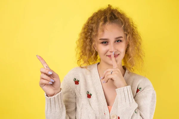 Uma Jovem Com Cabelo Encaracolado Aponta Com Gesto Fundo Estúdio — Fotografia de Stock