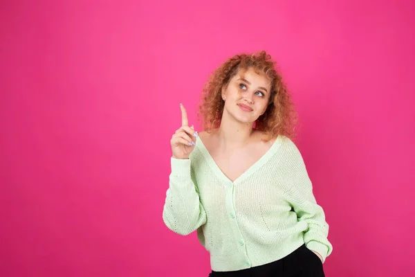 Een Jong Meisje Met Krullend Haar Punten Met Een Gebaar — Stockfoto