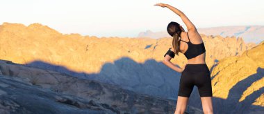 Spor giyimli genç, zayıf, atletik bir kız bir takım egzersizler yapıyor. Fitness ve sağlıklı yaşam tarzı.