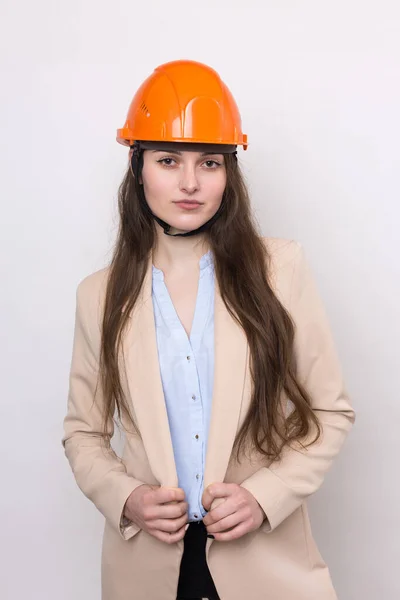 Ένα Κορίτσι Αρχιτέκτονας Ένα Κοστούμι Και Ένα Πορτοκαλί Κράνος Στέκεται — Φωτογραφία Αρχείου