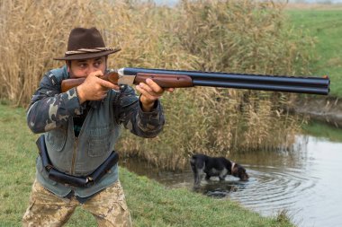 Avlanırken av sırasında av hayvanı ya da av hayvanı arayan kamuflajlı bir avcı. Sonbahar av sezonu.