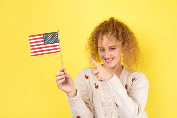 一个脸上挂着笑容的年轻快乐的女孩手里拿着一面美国国旗 爱国主义和自由的象征 — 图库照片