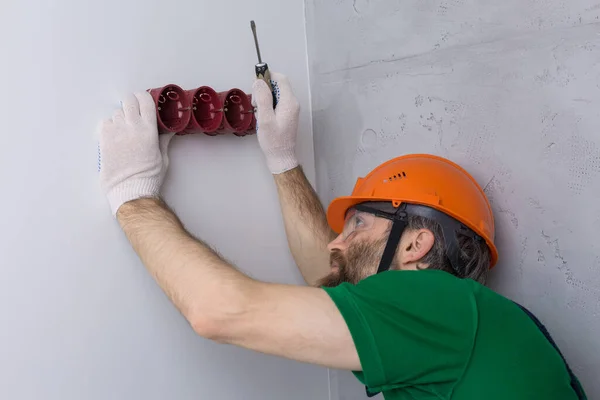 Elektriker Installerar Uttag Lägenheten Kille Orange Hjälm Och Overaller Gör — Stockfoto