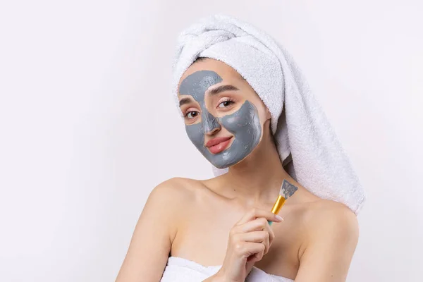 Een Vrouw Met Een Grijze Klei Cosmetische Masker Een Witte — Stockfoto