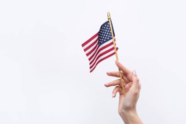 Güzel bir kadın eli beyaz bir arka planda Amerikan bayrağı taşıyor..