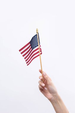 Güzel bir kadın eli beyaz bir arka planda Amerikan bayrağı taşıyor..