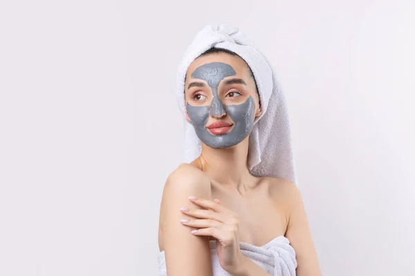 Een Vrouw Met Een Grijze Klei Cosmetische Masker Een Witte — Stockfoto