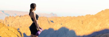 Spor giyimli genç, zayıf, atletik bir kız bir takım egzersizler yapıyor. Fitness ve sağlıklı yaşam tarzı.