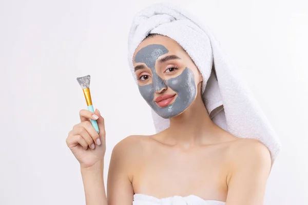 Een Vrouw Met Een Grijze Klei Cosmetische Masker Een Witte — Stockfoto