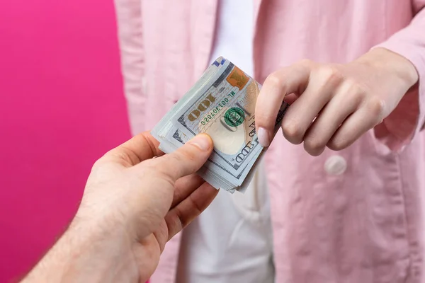 분홍색 자켓을 여자는 배경에 달러로 뇌물을 받는다 — 스톡 사진