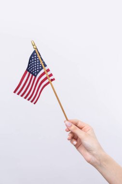Güzel bir kadın eli beyaz bir arka planda Amerikan bayrağı taşıyor..