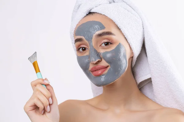 Een Vrouw Met Een Grijze Klei Cosmetische Masker Een Witte — Stockfoto