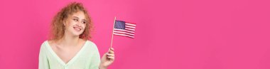 Yüzünde bir gülümseme olan genç mutlu bir kız ellerinde bir Amerikan bayrağı tutuyor. Vatanseverliğin ve özgürlüğün sembolü..