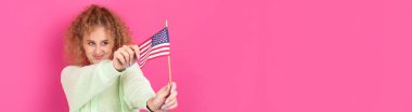 Yüzünde bir gülümseme olan genç mutlu bir kız ellerinde bir Amerikan bayrağı tutuyor. Vatanseverliğin ve özgürlüğün sembolü..