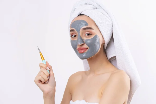 Een Vrouw Met Een Grijze Klei Cosmetische Masker Een Witte — Stockfoto