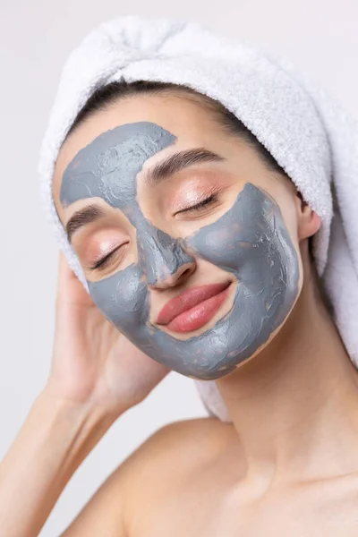 Een Vrouw Met Een Grijze Klei Cosmetische Masker Een Witte — Stockfoto