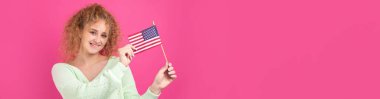 Yüzünde bir gülümseme olan genç mutlu bir kız ellerinde bir Amerikan bayrağı tutuyor. Vatanseverliğin ve özgürlüğün sembolü..