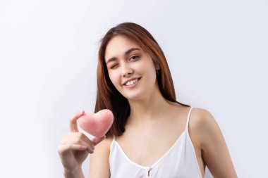 Temiz ciltli, doğal makyajlı ve gri arka planda beyaz dişli güzel bir kadın.