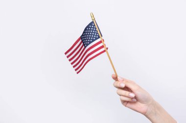 Güzel bir kadın eli beyaz bir arka planda Amerikan bayrağı taşıyor..