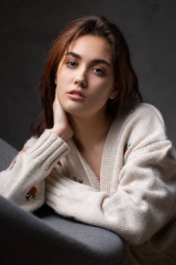 Stüdyoda uzun saçlı genç bir esmerin portresi. Koyu renkli dramatik fotoğraf.