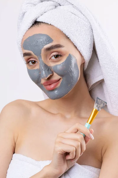 Een Vrouw Met Een Grijze Klei Cosmetische Masker Een Witte — Stockfoto